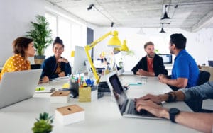 équipe d'une entreprise qui discute, tous équipés de matériel Apple